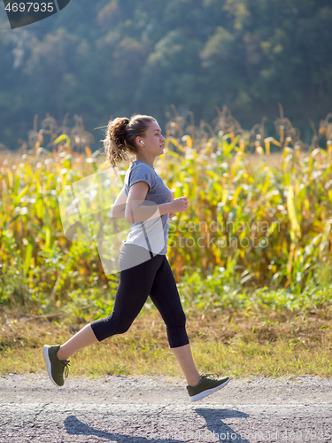 Image of woman jogging along a country road