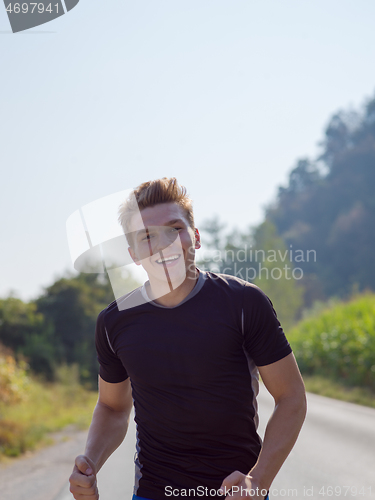 Image of man jogging along a country road