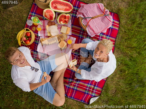 Image of top view of couple enjoying picnic time