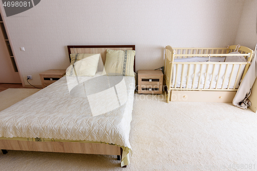 Image of Bedroom interior, adult bed and newborn\'s bed nearby
