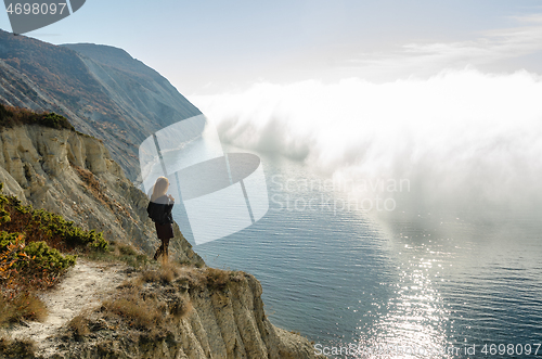 Image of Girl from the mountain watching the clouds above the sea