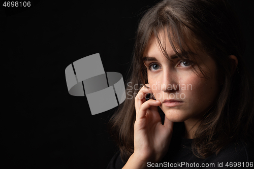 Image of Psychological portrait of a beautiful young girl on a black background