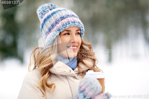 Image of happy woman drinking coffee outdoors in winter