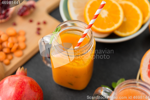 Image of mason jar glass of carrot juice with paper straw