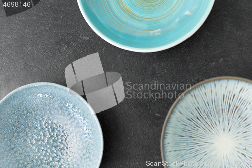 Image of close up of blue ceramic plate on slate background