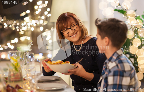 Image of grandmother and grandson having dinner at home