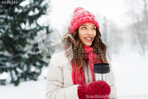 Image of young woman with hot drink in tumbler in winter