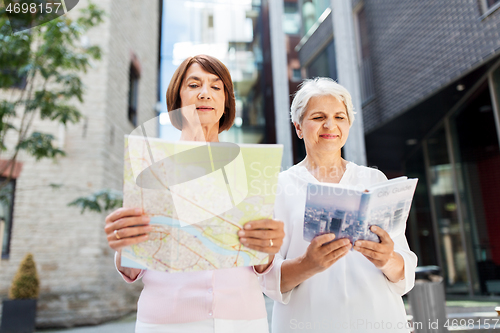 Image of senior women with city guide and map on street