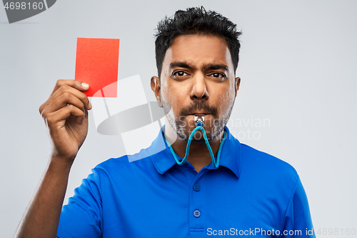 Image of indian referee whistling and showing red card