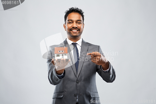 Image of indian man realtor with house model and folder