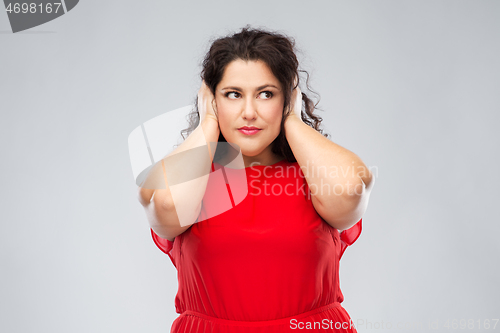 Image of woman in red dress closing her ears by hands