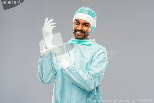 Image of indian male doctor or surgeon putting glove on
