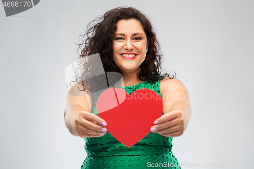 Image of happy woman in green dress holding red heart