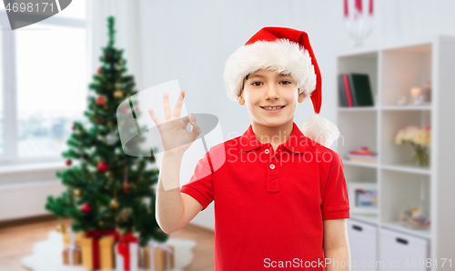 Image of smiling boy in santa helper hat showing ok gesture