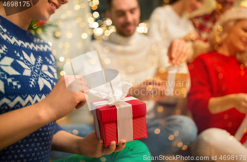 Image of close up of friends opening christmas gifts