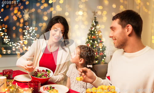 Image of happy family having christmas dinner at home