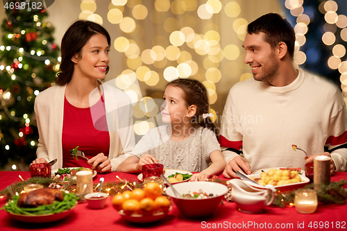 Image of happy family having christmas dinner at home