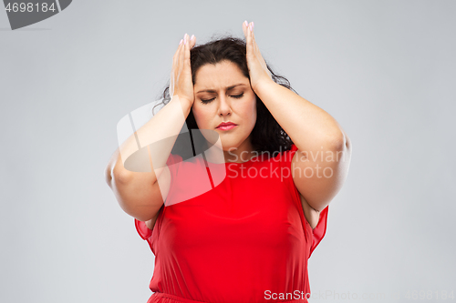 Image of woman in red dress suffering from headache