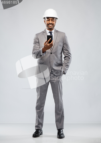 Image of indian male architect in helmet with smartphone