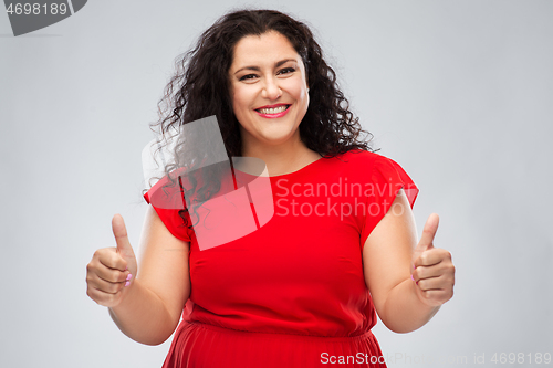 Image of happy woman in red dress showing thumbs up