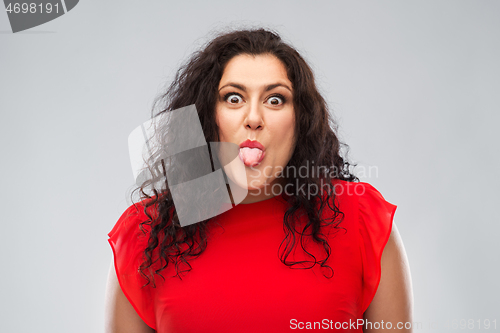 Image of happy woman in red dress showing tongue