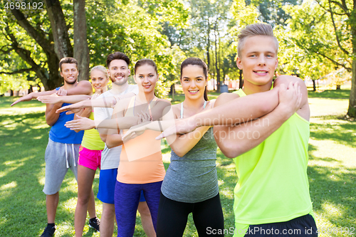 Image of group of happy people exercising at summer park