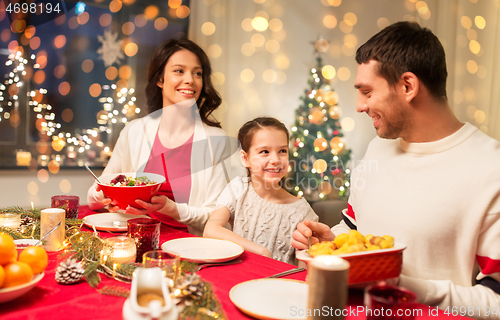 Image of happy family having christmas dinner at home