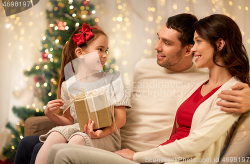 Image of happy family with christmas present at home