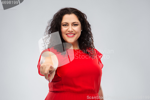 Image of happy woman in red dress pointing finger to you