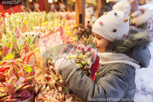 Image of little girl choosing sweets at christmas market