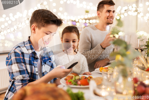 Image of children with smartphone at family dinner party