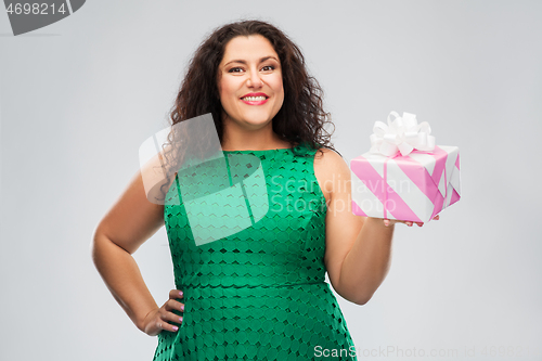 Image of happy woman in green dress holding gift box