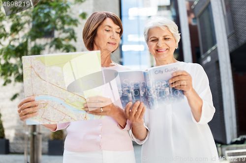 Image of senior women with city guide and map on street