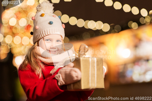 Image of happy girl with gift box at christmas market