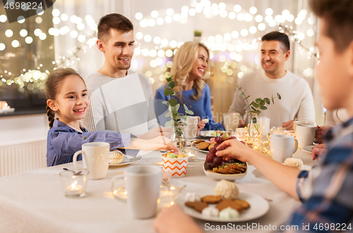 Image of happy family having tea party at home