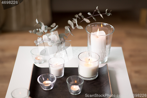 Image of burning fragrance candles on table at cozy home