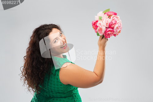 Image of happy woman in green dress with flower bunch