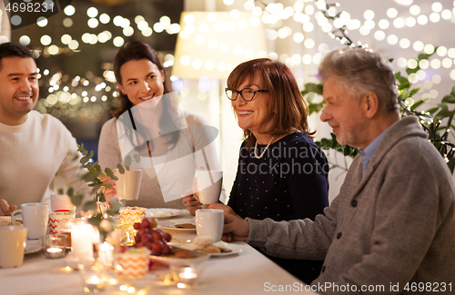 Image of happy family having tea party at home