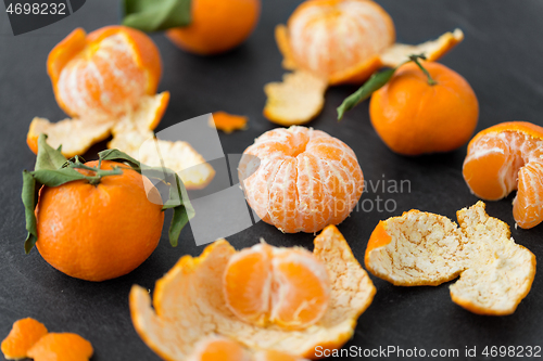 Image of close up of peeled mandarins on slate table top