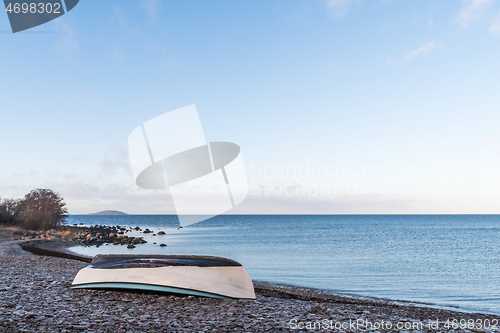 Image of Rowboat overturned on land by seaside