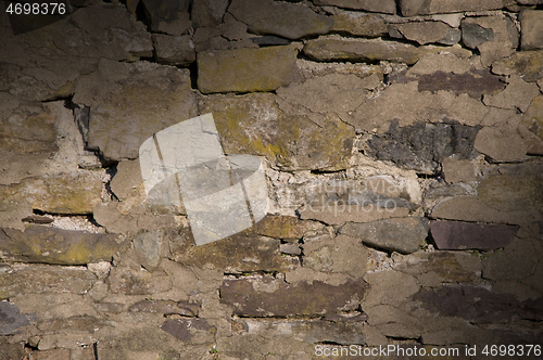 Image of Cracked dilapidated masonry wall lit diagonally