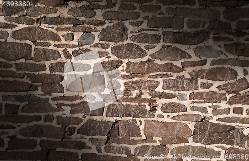 Image of Old masonry wall using irregular stones lit diagonally