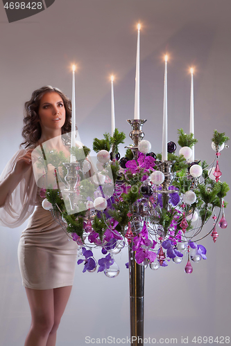 Image of Young Woman And Chandelier With Flowers