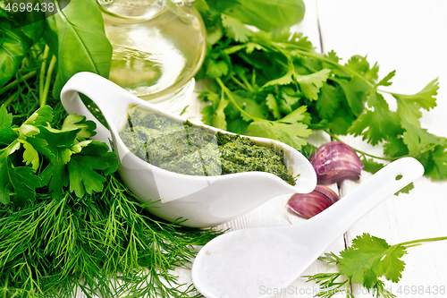 Image of Sauce of spicy greens in gravy boat on white board