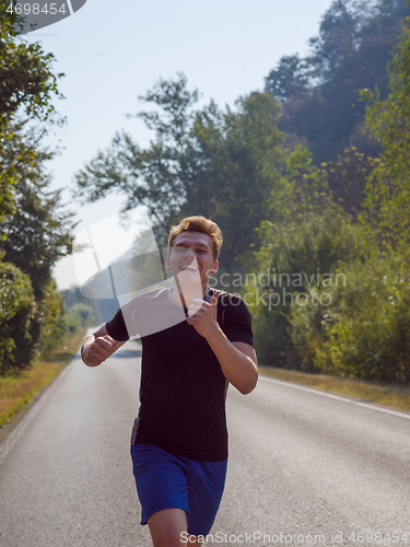 Image of man jogging along a country road