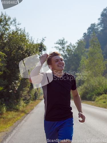 Image of man jogging along a country road