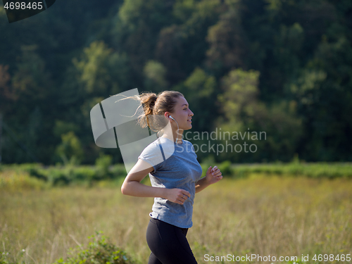 Image of woman jogging along a country road