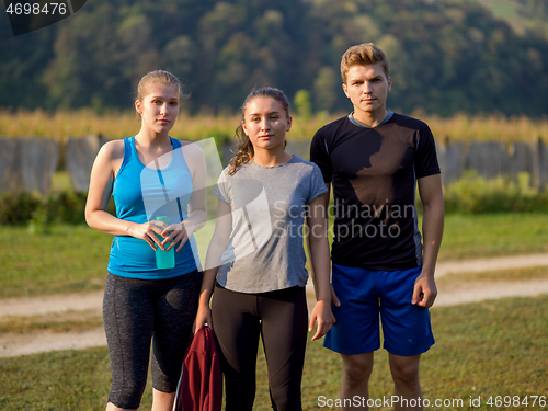 Image of young people jogging on country road