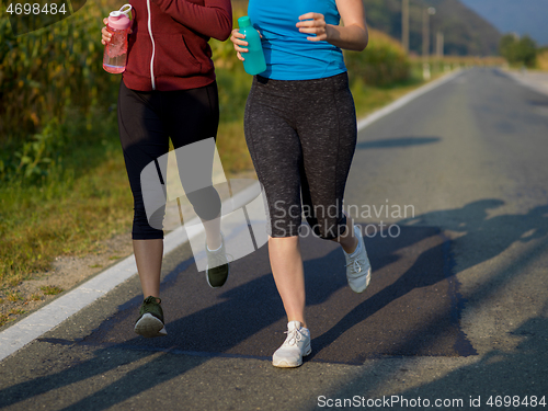 Image of women jogging along a country road