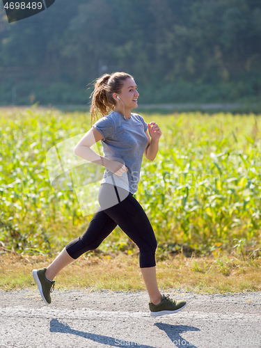 Image of woman jogging along a country road